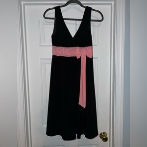 Black v-neck flowy aline dress with pink bow.